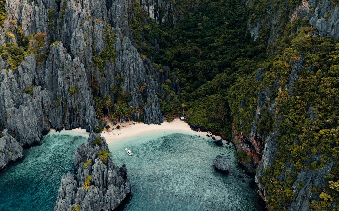 Lagon turquoise cerné de falaises calcaires, vu du ciel