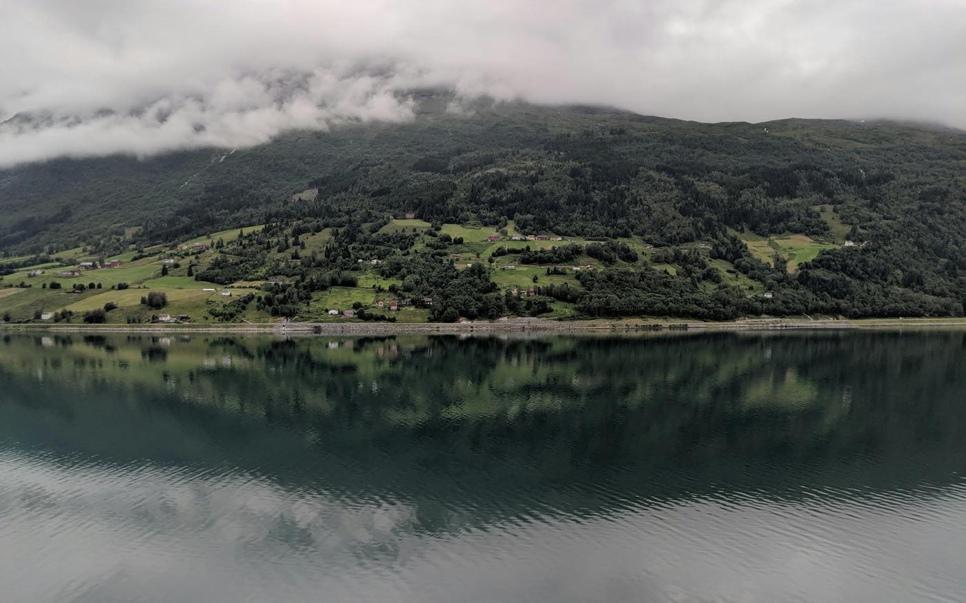 Fjord norvégien au petit matin, eau lisse et parois sombres